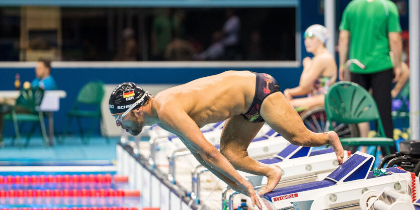 Ein Mann springt in einen Pool