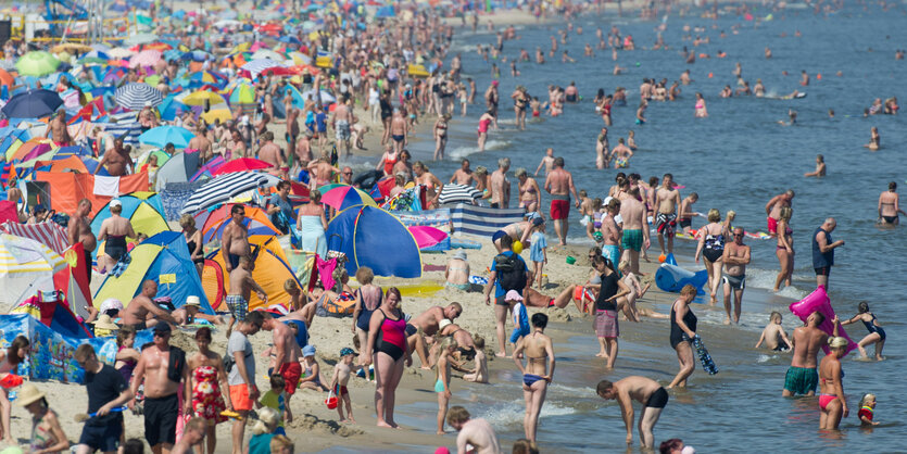 Ganz viele Menschen stehen an einem Strand