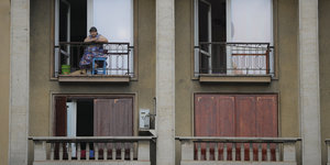 Eine Frau schaut vom Balkon