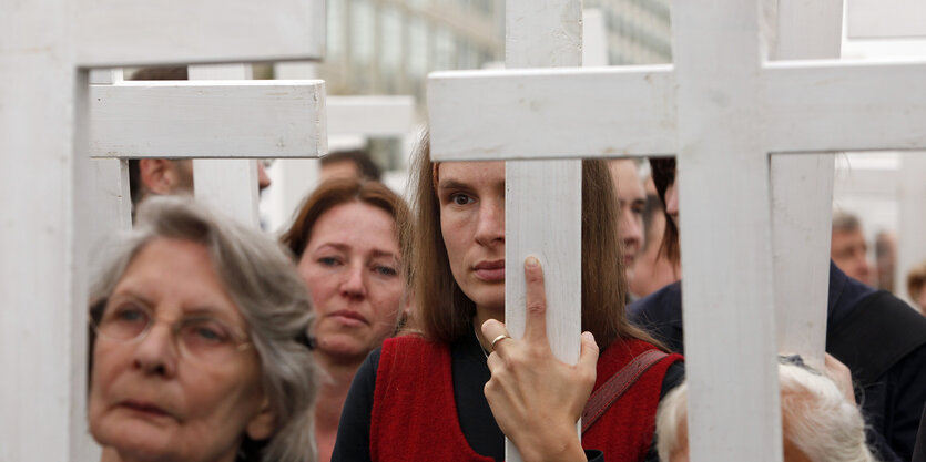 Menschen tragen Holzkreuze vor sich her