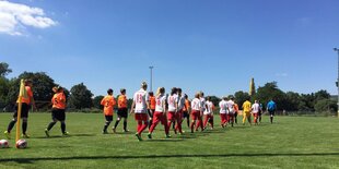 Zwei Frauenfußballteams laufen auf den Rasen