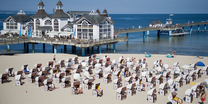 Menschen am Strand vor prächtigem Ostseebad