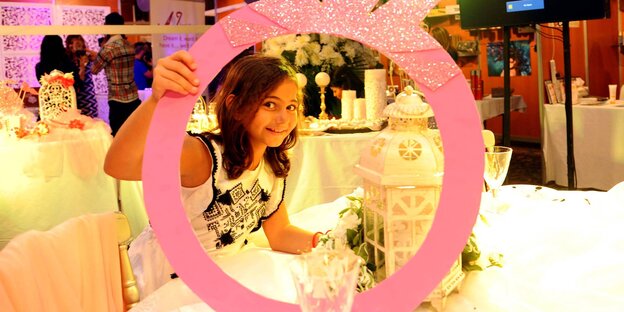 Ein junges Mädchen posiert hinter einem großen Ehering