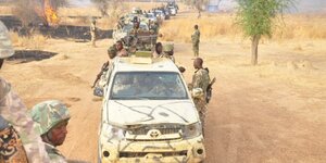 Ein langer Autokonvoi eines Militärs in einer wüstenähnlichen Gegend