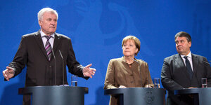 Horst Seehofer, Angela Merkel und Sigmar Gabriel stehen an Pulten
