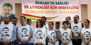 Eine Gruppe Menschen mit T-Shirts, auf denen der Kopf Abdullah Öcalans abgebildet ist