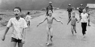 Kinder, darunter auch ein nacktes Mädchen, fliehen vor einem Napalmangriff. Das Bild ist schwarz-weiß