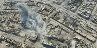 Die syrische Stadt Aleppo von oben, in der linken Hälfte des Bildes sind Rauchschwaden über den Häusern