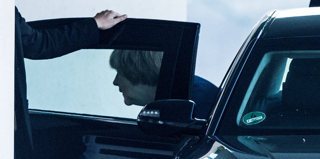 Angela Merkel steigt aus einem schwarzen Auto aus, jemand hält ihr die Tür auf