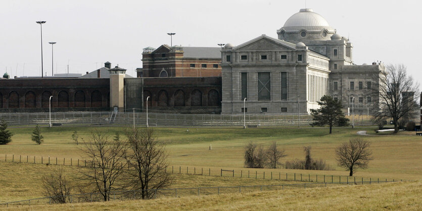 Ein monumentaler Gefängnisbau aus den USA, im Vordergrund Weideland