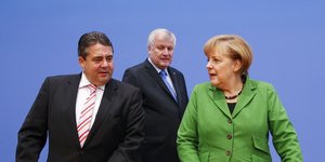 Sigmar Gabriel und Angela Merkel wenden sich die Köpfe zu, hinter ihnen steht Horst Seehofer