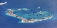 Eine Luftaufnahme eines Atolls, in dem viele Boote liegen