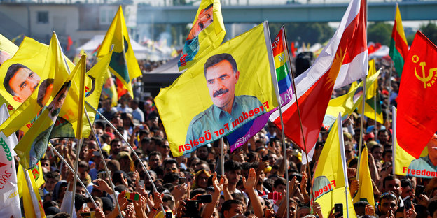 Menschen halten Fahnen mit dem Porträt Öcalans in die Höhe