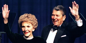 Der ehemalige US-Präsident Ronald Reagan und seine Frau Nancy lächeln und winken 1994