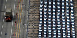 Reihe um Reihe fabrikneuer Autos auf einem Parkplatz in Singapur