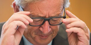 Jean-Claude Jucnker rückt seine Brille zurecht und guckt nach unten