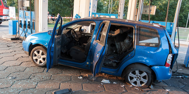 ein Auto mit explodiertem Tank in Blau an einer Tankstelle