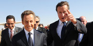 Nicolas Sarkozy und David Cameron steigen aus einem Flugzeug am Flughafen in Benghazi