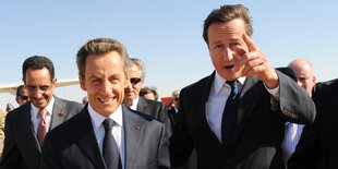 Nicolas Sarkozy und David Cameron steigen aus einem Flugzeug am Flughafen in Benghazi