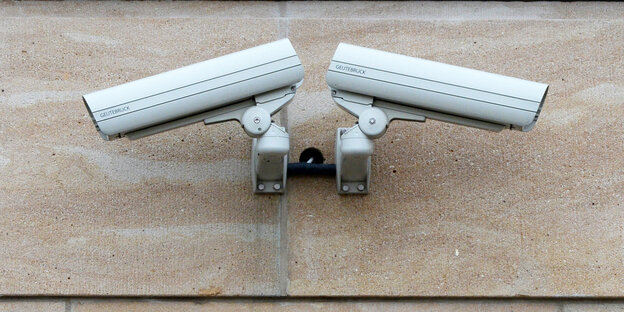 Zwei Videokameras hängen an einer Wand