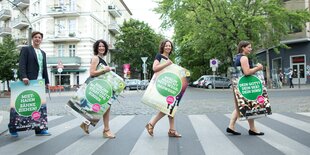 Daniel Wesener, Bettina Jarasch, Ramona Pop und Antje Kapek tragen Wahlplakate über einen Zebrastreifen