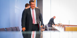 Sigmar Gabriel spiegelt sich in einem leeren Tisch vor ihm