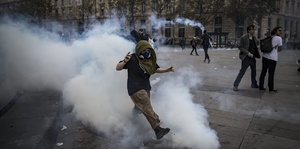 ein Demonstrant in einer Tränengaswolke
