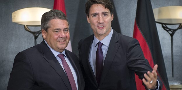 Gabriel und Trudeau posieren vor Nationalflaggen für die Kamera