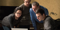 Vier Personen schauen gebannt auf einen Laptop. Es ist eine Filmszene aus „Snowden“