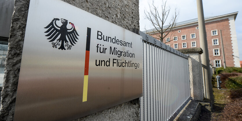 ein Schild mit der Aufschrift „Bundesamt für MIgration und Flüchtlinge“ häng am Pfosten eines Eingangtor