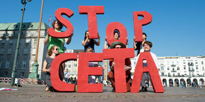 Menschen, die Buchstaben hochhalten, die die Wörter "Stop Ceta" ergeben
