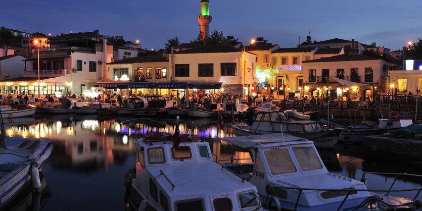 Der alte Hafen von Bozcaad in der Dämmerung, die Uferpromenade ist hell erleuchtet