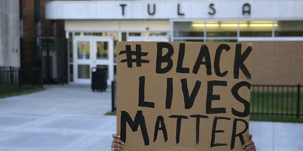 Ein Demonstrant mit einem Black-Lives-Matters-Shirt ruft durch ein Megafon