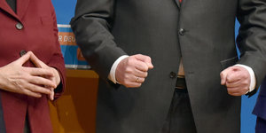 Angela Merkels Hände formen eine Raute, Horst Seehofers Hände sind zu Fäusten geballt
