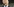 Ein Mann spricht in ein Mikrofon. Es ist Donald Trump