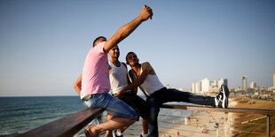 Drei Jungs machen ein Selfie an der Strandpromenade