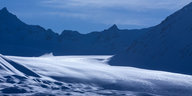 Ein Gletscher zwischen dunklen Bergspitzen