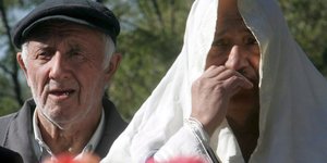 Ein Mann und eine Frau stehen weinend vor dem Menora-Monument, das an das Massaker von Babi Jar erinnert