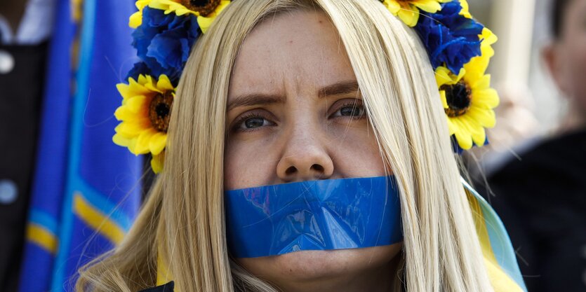 Frau mit blauem Klebeband vor dem Mund