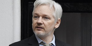 Julian Assange guckt fragend nach rechts