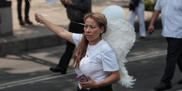 Eine Frau mit aufgeschnallten Engelsflügeln auf einer Demo gegen die Homo-Ehe