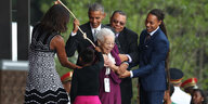 Michelle und Barack Obama läuten zusammen mit einer Zeitzeugin und ihrer Urenkelin eine Glocke