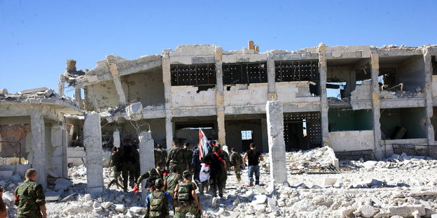 Soldaten vor einem völlig zerstörten Gebäude