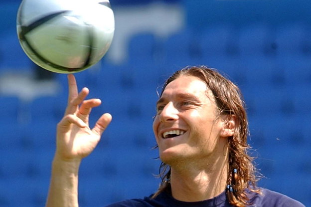 Francesco Totti balanciert einen Fußball auf seinem Mittelfinger und lächelt