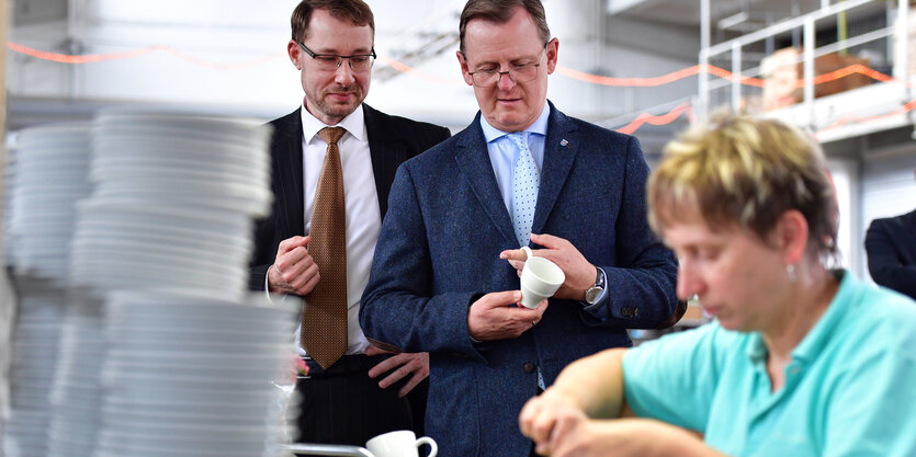 Bodo Ramelow steht vor der Mitarbeiterin einer Porzellanfabrik