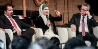 de Maiziere sitzt auf dem Podium neben Tuba Isik und Aiman Mazyek vom Zentralrat der Muslime