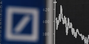 das Logo der Deutschen Bank mit einem nach unten gehenden Aktienkurs