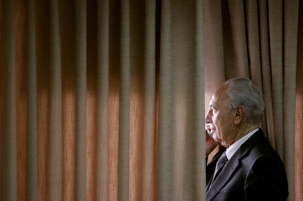 Peres blickt während eines Telefonats kurz vor der Wahl 2007 durch Gardinen aus einem Fenster