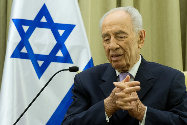 Schimon Peres sitzt im Jahr 2014 vor der israelischen Flagge