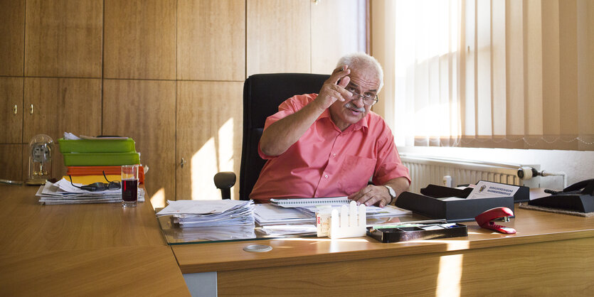 ein Büro, am Schreibtisch sitzt Bürgermeister Lupart